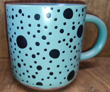 Tasse grün mit dunklen Punkten
